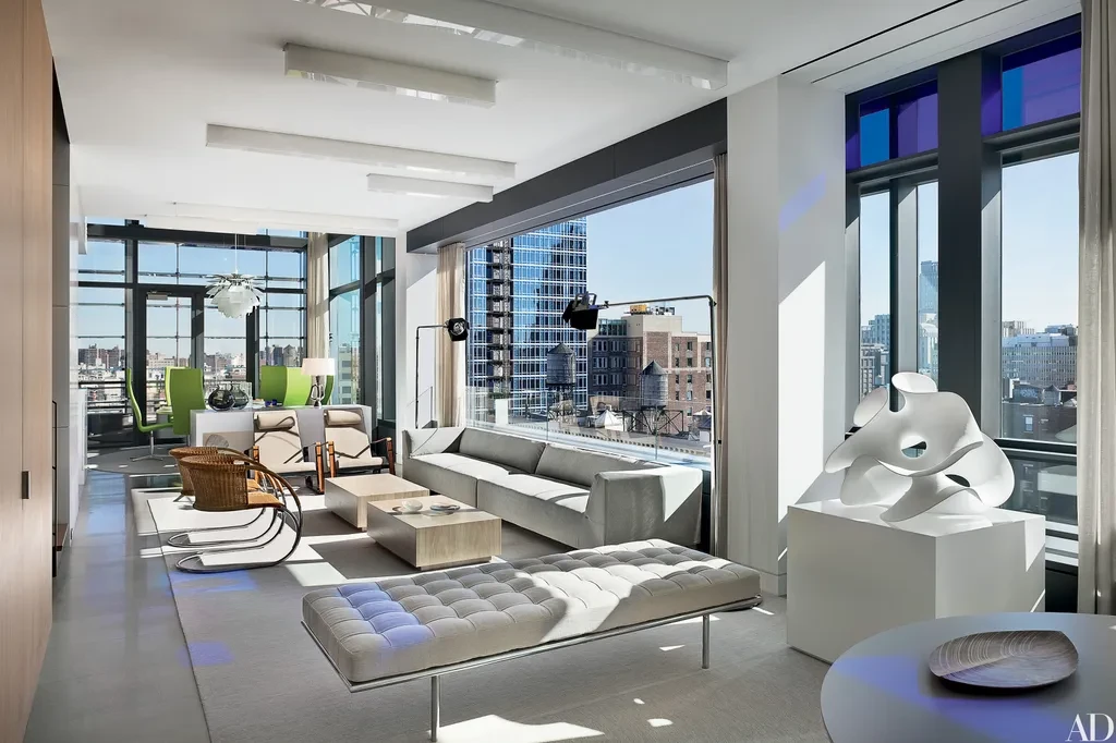 A modern loft living room with a grey sofa and wraparound windows